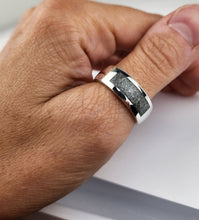 Charger l'image dans la galerie, Gros plan d'une main portant une bague élégante avec des inclusions Bague Horizon de MONA fine joaillerie dans l'insert texturé foncé, mettant en valeur un design de bijoux moderne.