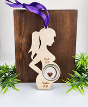 Charger l'image dans la galerie, Un ornement personnalisé de faire-part de grossesse Femme enceinte en bois comportant des silhouettes et des noms avec des années de naissance, élégamment affichés sur un fond en bois avec de subtils accents de feuillage vert. Cette décoration en bois comprend des gravures sur bois détaillées de Concepts 3DG Inc.