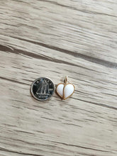 Charger l'image dans la galerie, Une petite pièce en argent est posée à côté du Pendentif Nourri-Source 12mm de MONA fine joaillerie sur une surface en bois clair. Le pendentif a un contour en or 10 carats et un centre blanc, montrant une comparaison de taille avec la pièce.