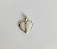 Charger l'image dans la galerie, Le Pendentif Nourri-Source 12mm de MONA Fine Joaillerie est un pendentif en or en forme de coeur avec un contour doré vide et un intérieur en émail blanc. Cette pièce de 10 carats présente une finition lisse et possède une boucle en haut pour l'attacher à un collier, sur un fond blanc uni.