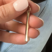 Charger l'image dans la galerie, Gros plan d'une main tenant une fine boucle d'oreille Pendentif Aiden de MONA joaillerie au design simple et élégant.