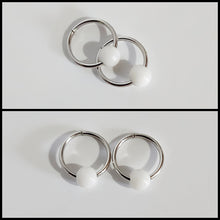 Charger l'image dans la galerie, Deux images des Boucles d'oreilles Dormeuses de la joaillerie fine MONA illustrent l'élégance. L'image du haut montre les anneaux circulaires en argent avec des perles blanches qui se chevauchent, tandis que l'image du bas présente ces boucles d'oreilles exquises côte à côte sur un fond blanc immaculé.