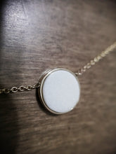 Charger l'image dans la galerie, Un gros plan d'un pendentif Collier Cabella de MONA joaillerie fine, scintillant sur une délicate chaîne en or et reposant sur une surface en bois, évoquant un sentiment d'élégance subtile.