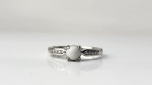 Charger l'image dans la galerie, Une bague unique Bague Précieuse de 5 mm avec une pierre centrale et des accents de diamants sur fond blanc par MONA fine joaillerie.
