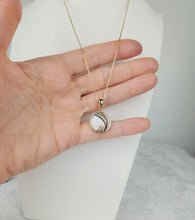 Charger l'image dans la galerie, Un délicat collier en or avec un pendentif Pendentif Cabella de MONA fine joaillerie, élégamment exposé sur une main sur un fond minimaliste.