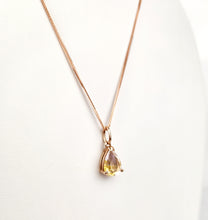 Load image into Gallery viewer, Ce superbe Pendentif Goutte Éternelle de la maison de joaillerie MONA présente un pendentif en forme de larme avec une pierre précieuse jaune éclatante. La fine et élégante chaîne repose gracieusement sur un fond clair, incarnant une élégance intemporelle.