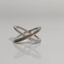 Charger l'image dans la galerie, Une Bague Crossover de joaillerie fine MONA élégante avec un design entrecroisé, orné de petits zircons couleur diamant, affichés sur une surface réfléchissante.