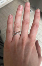 Charger l'image dans la galerie, La main d'une personne montrant une Bague Crossover de joaillerie fine MONA à motifs entrecroisés sur son annulaire.