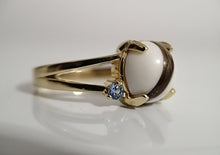 Charger l'image dans la galerie, Une Bague Angélique personnalisable élégante en or avec une grande perle blanche, complétée par une petite pierre précieuse bleue de MONA fine joaillerie.