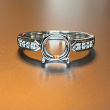 Charger l'image dans la galerie, Bague de fiançailles élégante avec une pierre centrale manquante affichée sur une surface réfléchissante, mettant en valeur son anneau détaillé avec de petits accents de zircon, la Bague Précieuse 8 mm de MONA fine joaillerie brille de mille feux.