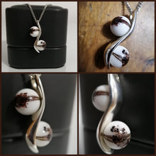 Charger l'image dans la galerie, Un collage de bijoux élégants mettant en valeur un pendentif en argent "S" de MONA fine joaillerie au design entrelacé, comportant des éléments sphériques avec un motif marbré blanc et marron ressemblant au lait maternel, présenté sur un présentoir noir et vu de