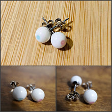 Charger l'image dans la galerie, Un collage de quatre images présentant une paire de Bijoux La Précieuse Boucle d'oreille Perles sur une surface en bois, avec des vues rapprochées mettant en valeur leurs délicates montures en argent et le jeu subtil de couleurs sur les surfaces sphériques, incorporant