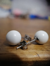 Charger l'image dans la galerie, Une paire de boucles d'oreilles à tige Bijoux La Précieuse Boucle d'oreille Perles sphériques blanches reposant sur une surface en bois.