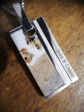Charger l'image dans la galerie, Gros plan d'un collier pendentif personnalisé Pendentif homme 1.0 avec les noms "jade & chloé" inscrits sur une plaque métallique de MONA fine joaillerie, avec un motif de fond moucheté.