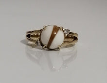 Charger l'image dans la galerie, Une élégante bague en or avec une pierre précieuse à bandes blanches et brunes, flanquée de petits diamants étincelants, disponible sous le nom de "Bague Angélique" chez MONA fine joaillerie.