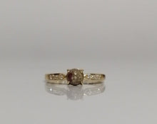 Charger l'image dans la galerie, Une bague solitaire en or Bague Précieuse de 5 mm avec une pierre précieuse rouge centrale en lait maternel flanquée de petits diamants, présentée sur un simple fond blanc. Nom de la marque : MONA fine joaillerie