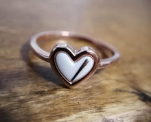Charger l'image dans la galerie, Une Bague Coeur en or rose, en forme de cœur, avec une incrustation de nacre, présentée sur une surface en bois chez MONA fine joaillerie.