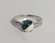 Charger l'image dans la galerie, Une élégante Bague Précieuse 8 mm de MONA fine joaillerie avec une pierre précieuse bleue et blanche unique, sertie dans une bande dorée avec de petits zircons accentuant ses épaules.