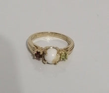 Charger l'image dans la galerie, Une élégante bague Bague Trinité avec une pierre centrale blanche flanquée de petites pierres précieuses colorées de la Bijouterie Langlois sur un fond blanc uni.