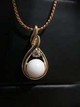 Charger l'image dans la galerie, Un élégant Pendentif Amiko avec une pièce maîtresse en perles et un accent de diamants zircon colorés sur une chaîne en or torsadée, présenté sur un fond sombre dans la Bijouterie Langlois, respirant la sophistication et la beauté intemporelle.