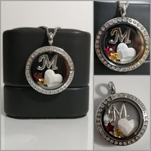 Charger l'image dans la galerie, Un collage de trois vues d'un Pendentif Médaillon personnalisé avec la lettre "m" présentée sur un présentoir en acier inoxydable - la vue centrale avec un cœur, deux pierres de naissance et des images environnantes se concentrant sur le pendentif de Bijoux La Précieuse.