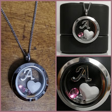 Charger l'image dans la galerie, Un collage d'images présentant un collier Pendentif Médaillon personnalisé avec la lettre « a » sur une breloque en acier inoxydable, complété par des pierres de naissance roses décoratives et des accents blancs en forme de cœur, affichés contre Bijoux La Précieuse.