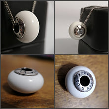 Charger l'image dans la galerie, Un collage de quatre images présentant un pendentif sphérique Bijoux La Précieuse Perle européenne avec un texte gravé, vu sous différents angles et orientations, symbolisant l'inclusion.