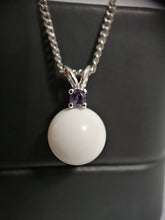 Charger l'image dans la galerie, Un collier en argent avec un pendentif Juri surmonté d'une petite pierre précieuse violette, serti sur un fond sombre, réalisé en argent sterling 925 par la Bijouterie Langlois.