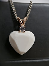 Charger l'image dans la galerie, Un élégant pendentif blanc en forme de cœur Pendentif Juri avec une pierre de naissance étincelante en son sommet, suspendu à une chaîne en argent sterling 925 sur un fond sombre. (Bijouterie Langlois)