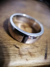 Charger l'image dans la galerie, Un gros plan d'une bague d'inclusion de bande bicolore Bague Homme avec une finition texturée, posée sur une surface en bois par MONA fine joaillerie.