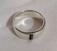 Charger l'image dans la galerie, Une Bague Homme de MONA fine joaillerie, avec une inscription sur le jonc intérieur, reposant sur une surface en tissu blanc.
