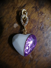 Charger l'image dans la galerie, Un élégant Pendentif Shawna en argent en forme de cœur avec une pierre violette étincelante, amoureusement embrassée par une boucle dorée ornée de petits zircons, reposant sur une surface en bois. (Bijoux La Précieuse)