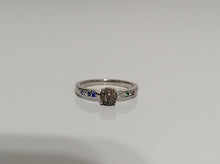Charger l'image dans la galerie, Une élégante bague Bague Précieuse de 5 mm avec un diamant central et de petites pierres précieuses colorées le long de l'anneau, présentées sur un fond blanc. Cette pièce fait partie du bijou personnalisé de MONA fine joaillerie.