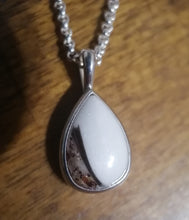 Charger l'image dans la galerie, Un élégant Pendentif Goutte15 de MONA fine joaillerie avec une monture en argent et une chaîne, mettant en valeur une pierre de lait maternel lisse et opaque avec une inclusion sombre unique près du fond.