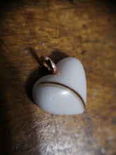 Charger l'image dans la galerie, Un gros plan d'un Pendentif Oeillet de MONA fine joaillerie avec une inclusion lait maternel et une bélière dorée sur une surface en bois.