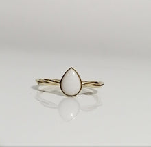 Charger l'image dans la galerie, Une bague élégante avec une pierre en forme de poire sertie sur une Bague Twist de la fine joaillerie MONA, affichée sur une surface réfléchissante.