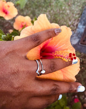 Charger l'image dans la galerie, Une main au nail art scintillant touchant doucement les pétales d'une fleur d'hibiscus orange vif, mettant en valeur une bague MONA fine joaillerie Bague Maëva à l'annulaire.
