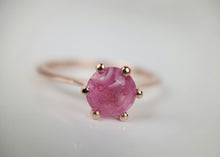 Load image into Gallery viewer, Un gros plan de la Bague Solitaire Éternelle de MONA Fine Joaillerie, ornée d&#39;une pierre précieuse ronde rose au motif tourbillonnant, maintenue en place par six griffes. La bague Or 10k est posée sur un fond doux et flou.
