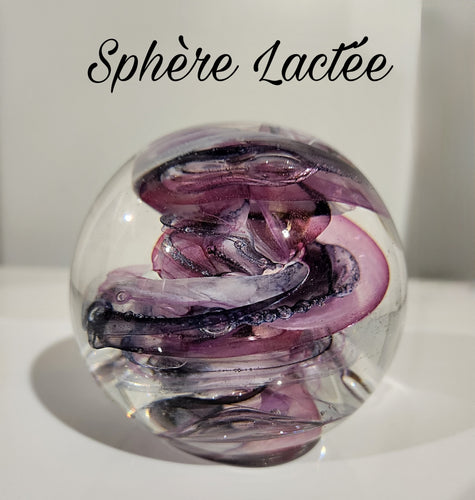 Presse-papier en verre avec un motif complexe de tourbillons violets et blancs à l'intérieur, ressemblant à une galaxie cosmique, intitulé 