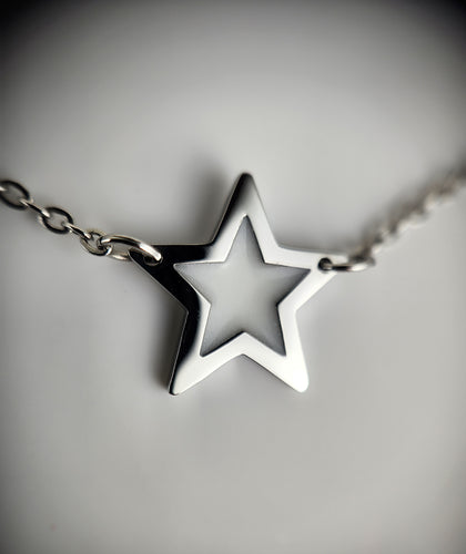 Gros plan d'un pendentif étoile brillant suspendu à un bracelet Bijoux La Précieuse Étoile, symbolisant l'élégance et la simplicité.