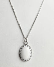Charger l&#39;image dans la galerie, Élégant collier en acier inoxydable avec un simple pendentif ovale Pendentif Griffes sur fond texturé par Bijoux La Précieuse.
