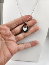 Load image into Gallery viewer, Un délicat Pendentif en bois en forme de cœur de Concept 3DG Inc. exposé sur un support à bijoux buste, doucement bercé entre les doigts d&#39;une personne, mettant en valeur son design et son savoir-faire.

