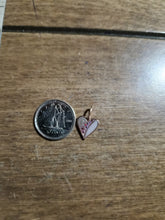 Charger l&#39;image dans la galerie, Une pièce de 10 cents canadiens se trouve à côté du Pendentif Mini Coeur de MONA fine joaillerie, un petit pendentif en forme de cœur avec un motif rose et blanc comportant de minuscules fleurs rouges, tous deux placés sur une surface en bois brun.
