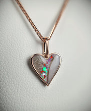 Charger l&#39;image dans la galerie, Gros plan sur le &quot;Pendentif Mini Coeur&quot; de MONA fine joaillerie : un collier à chaîne en or avec un pendentif en forme de cœur composé de fragments iridescents et pailletés en résine transparente avec une bordure dorée, le tout sur un fond texturé blanc doux.

