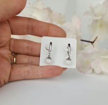 Load image into Gallery viewer, Une personne tient une carte affichant une paire de boucles d&#39;oreilles Boucles d&#39;oreilles Fermoirs de la Bijouterie Langlois avec des fleurs en arrière-plan flou.
