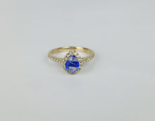 Charger l&#39;image dans la galerie, La Bague Bonheur Éternel de la Bijouterie Langlois est une bague en or 10 carats avec une superbe pierre centrale goutte bleue en son centre, entourée de petits diamants. L&#39;anneau est également orné de minuscules diamants, rehaussant son éclat et son élégance. Présentée sur une surface blanche unie, cette pièce est vraiment exquise.
