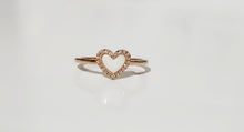 Charger l&#39;image dans la galerie, La Bague Coeur avec zircons de MONA fine joaillerie est une anneau minimaliste en or, ornée d&#39;un cœur blanc central entouré de zircons scintillants, présentée sur un fond blanc épuré.
