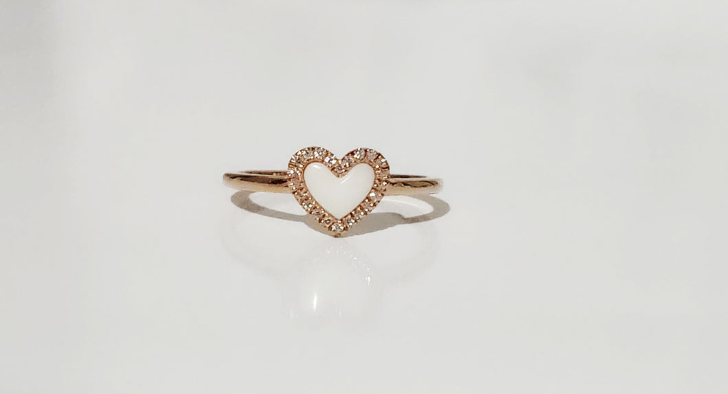 La Bague Coeur avec zircons de MONA fine joaillerie est une anneau minimaliste en or, ornée d'un cœur blanc central entouré de zircons scintillants, présentée sur un fond blanc épuré.