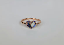 Charger l&#39;image dans la galerie, La Bague Coeur avec zircons de MONA fine joaillerie est une bague minimaliste en or dont le centre en forme de cœur est souligné de petites pierres bleues, présentées sur une surface simple et légère.
