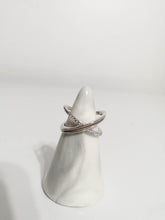 Load image into Gallery viewer, Un présentoir conique blanc présentant deux élégantes bagues en Or 10k avec zircons couleur diamant sur un fond minimaliste.
